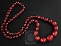 A single strand graduated simulated cherry amber oval bead necklace, gross 47 grams, 68cm.