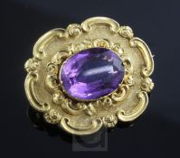 An early Victorian gold and amethyst set mourning brooch, of shaped oval form and decorated with