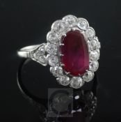A mid 20th century, platinum, ruby and diamond oval cluster ring, in a millegrain setting, with