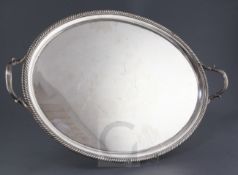 A George III silver oval two handled tea tray by Robert Garrard, with gadrooned border, reeded