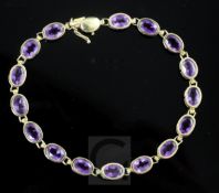 A modern 14ct gold and amethyst line bracelet, 18cm.