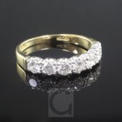 An 18ct gold and seven stone diamond half hoop ring, size R.