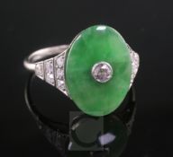 A 1920's style platinum, jadeite and diamond ring dress ring, the oval cut jade with central diamond