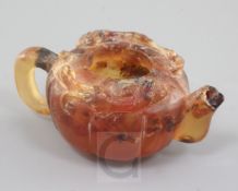 A Chinese amber small wine pot, of lobed form carved in relief with a pair of chi-dragons, length