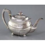 A George III silver oval teapot, by Wallis & Hayne, with engraved foliate band, on four ball feet,