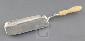 A Victorian silver crumb scoop with carved ivory handle, the scoop engraved with foliage, Henry
