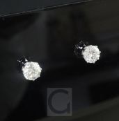 A pair of 18ct white gold and solitaire diamond ear studs, the two round cut stones weighing