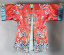 A Chinese red satin lady's robe, mid 19th century, decorated with floral medallions in Peking knot