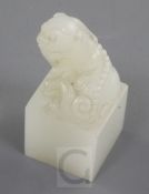 A Chinese white jade seal, early 20th century, carved with a lion-dog finial, the matrix with a four