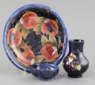 A Moorcroft pomegranate pattern dish, a tiger lily pattern small vase and a hibiscus pattern dish,