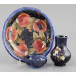 A Moorcroft pomegranate pattern dish, a tiger lily pattern small vase and a hibiscus pattern dish,