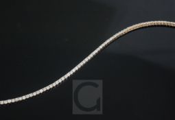 An 18ct rose gold and diamond set line bracelet, set with eighty three brilliants, with an