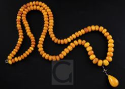 A single strand graduated disc shaped amber bead necklace with rose cut diamond and ruby set amber