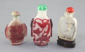 Three Chinese glass snuff bottles, late 19th / early 20th century, two in red cameo on a snowflake