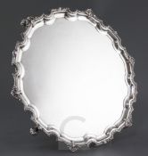 A 1970's shaped circular silver salver by Mappin & Webb, with shell and beaded pie crust border,