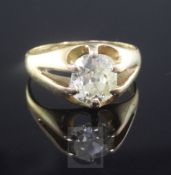 An 18ct gold and claw set solitaire diamond ring, the old cushion cut stone weighing in excess of