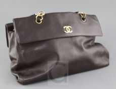 A ladies textured brown leather Chanel handbag, length 16in., with slip case