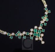 An 18ct gold, emerald and diamond necklace, set with twenty round cut emeralds and sixteen round cut