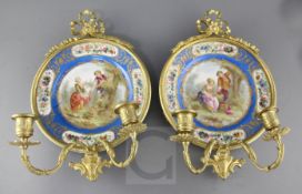 A pair of Sevres style porcelain plates, ormolu mounted as wall sconces, height 15in. diameter