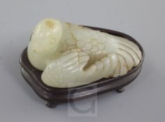 A Chinese celadon and russet jade figure of a recumbent bird, Ming dynasty, with detail to the