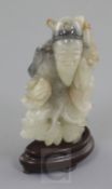 A Chinese white and black jade figure of an old man, 18th / 19th century, holding a sprig in his