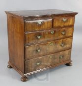 A George II walnut chest, with quarter veneered top, two short and three graduated long drawers,