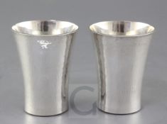 A pair of modern planished silver beakers by Simon J. Beer, (Lewes maker), with flared rims,