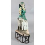 Manner of Louis Hottot. A painted spelter model of an Arab dancing girl leaning against a table,