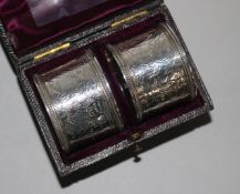 A cased pair of Victorian engraved silver napkin rings,