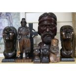 A collection of South American wood carvings, including a large bust of a bearded man, a pair of