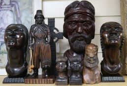 A collection of South American wood carvings, including a large bust of a bearded man, a pair of