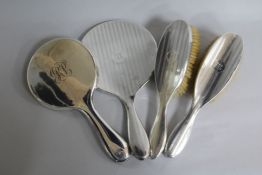 Two silver mounted hand mirrors and two silver mounted brushes.