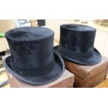 Two moleskin top hats, boxed