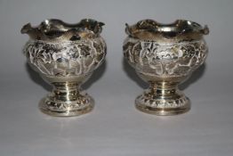 A pair of Indian white metal vases with wavy rims, height 82mm.