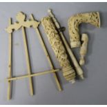 A carved ivory handle, a miniature ivory easel and other handles