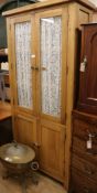 A pine glazed two door cupboard W.95cm