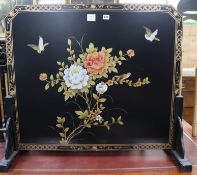 A Chinese black lacquered floral decorated fire screen W.93cm