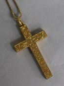 An early 20th century engraved 15ct gold cross pendant on a 9ct gold chain.