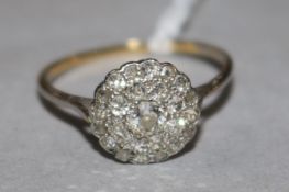 A 1920's yellow metal and diamond cluster dress ring, size O.