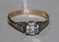 An 18ct gold and platinum single stone diamond ring with diamond set shoulders, size O.