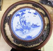 A carved blue and white Oriental screen inset with ceramic panel