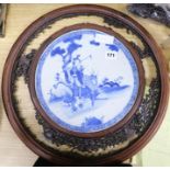 A carved blue and white Oriental screen inset with ceramic panel