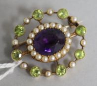 An Edwardian 15ct gold amethyst, peridot and pearl openwork brooch, in the suffragette colours,