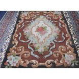 An Aubusson rug with central floral motif on a brown field 170 x 220cm