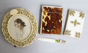 A carved ivory circular frame, an ivory page marker, a French aide memoir and a tortoiseshell card