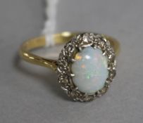 A gold and platinum, white opal and diamond oval cluster ring, size Q.