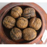 Seven Chinese carved walnuts, wood stand