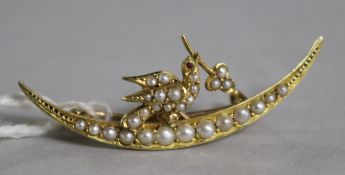 An Edwardian 15ct gold and seed pearl crescent and dove brooch, 39mm.