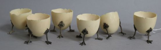 A set of six ivory egg cups, modelled as half egg shells of three chick leg supports, (one a.f.),