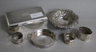 A silver cigarette box, a Victorian bon bon dish, three napkin rings and another dish.